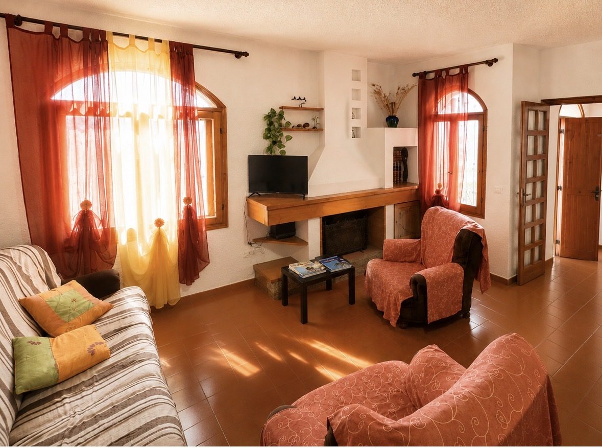 Soggiorno di Rainbow Sea House con camino e finestre ad arco