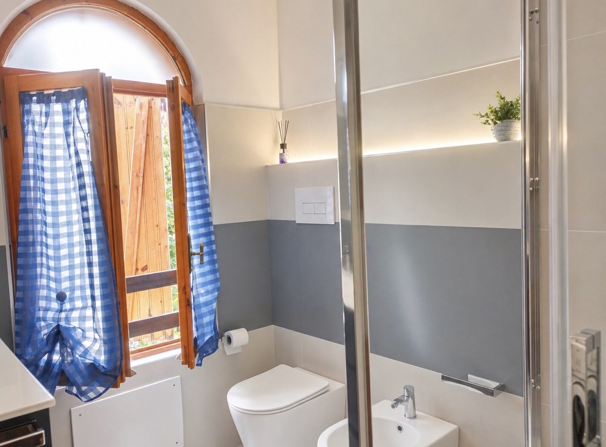 Bagno con lavatrice e finestra ad arco
